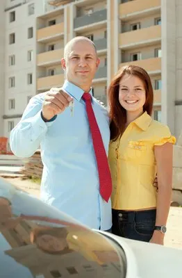 happy couple against real estate