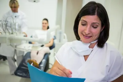 Female dentist writing report