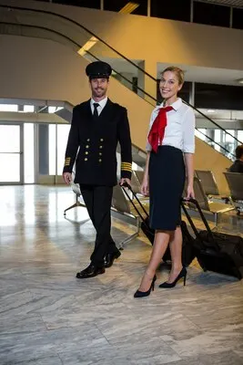Pilot and air hostess walking with their trolley bags