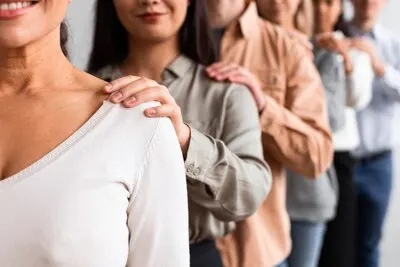 Smiley people touching shoulders at a group therapy session