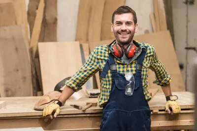 Portrait of a male carpenter standing in front of workbench