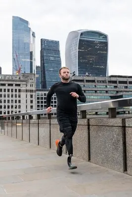 Full shot athlete running with prosthetic leg