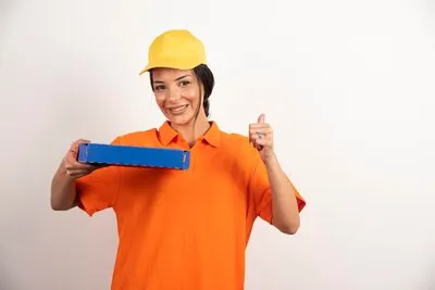 Delivery service woman holding pizza cardboard box .