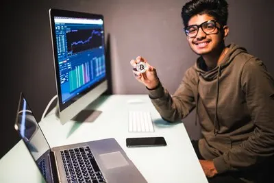 Indian trader with bitcoin checking stock trading data analysis concept working in office with financial graph on computer monitors