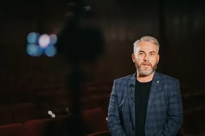 Elegant male theatre and movie director giving an interview in the auditorium