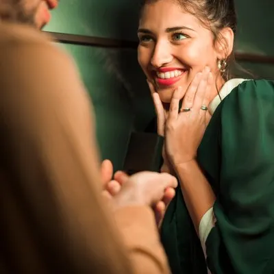 Guy presenting gift in box to attractive happy lady