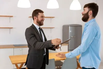 Real estate agent giving keys to new house to male buyer