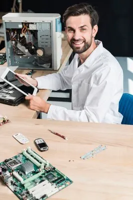 Portrait of a smiling young male technician holding digital tablet