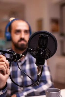 Close up of vlogger holding micophone while speaking during online interview