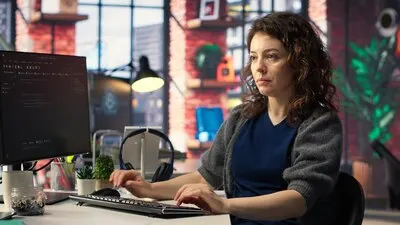 IT female technician uses coding language on computer at the agency
