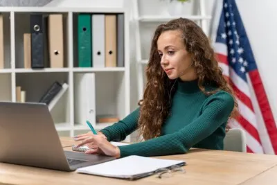 Medium shot girl with headphones and laptop indoors