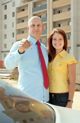 happy couple against real estate