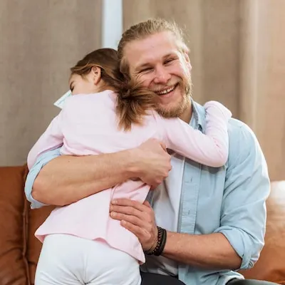 Little daughter embracing smiley father