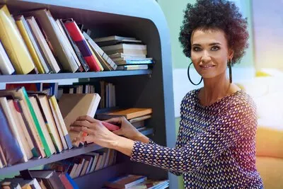 Woman kneeling next to the bookshelf