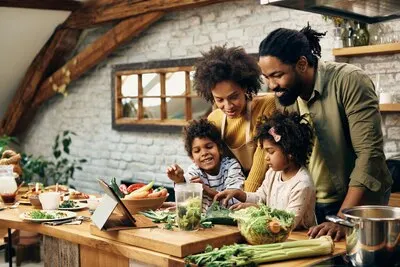 Happy black family preparing healthy food in the kitchen